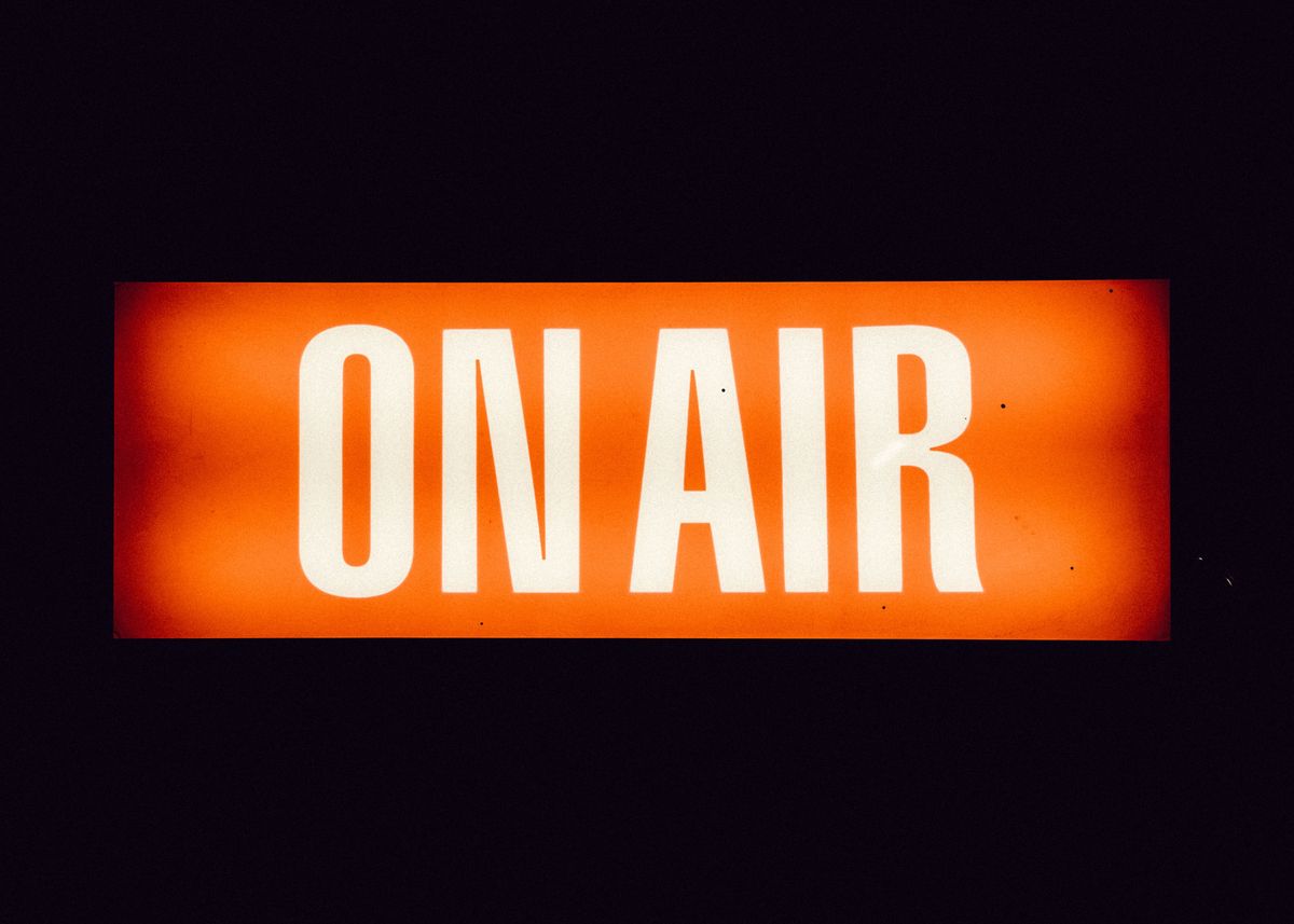 A red and white sign with the words "on air"